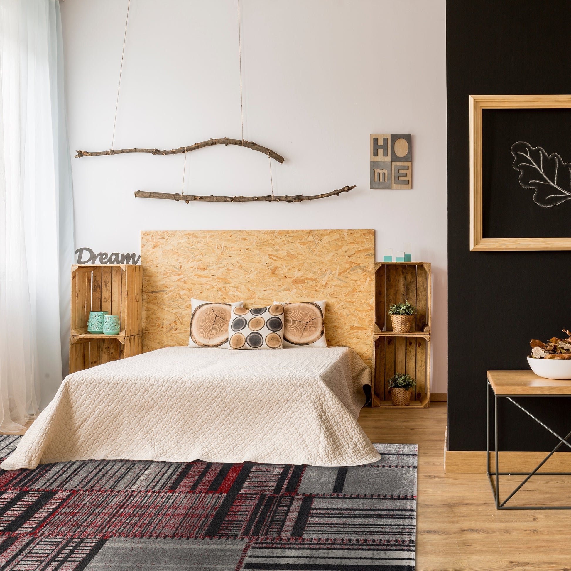 Cozy boho bedroom with large wooden panelled bed, wooden crate side tables, Twist Stripes Rug, black and white walls with nature-inspired decor 